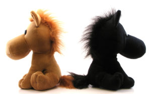 stuffed horses with backs together in a disagreement